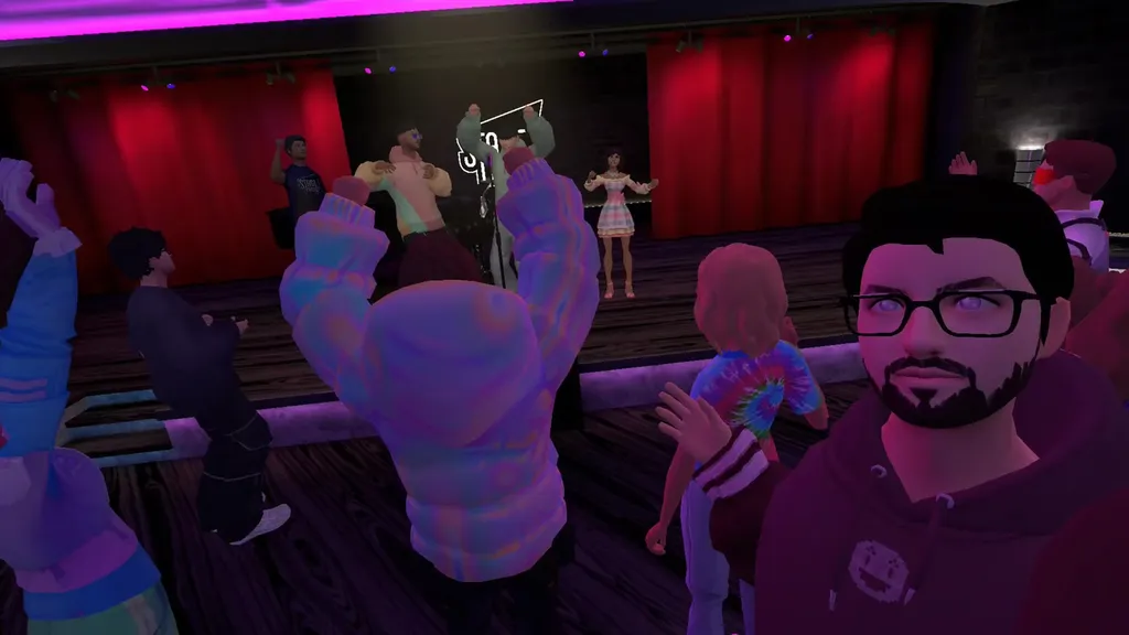 A virtual stage flanked by human avatars, one person turned towards the camera.